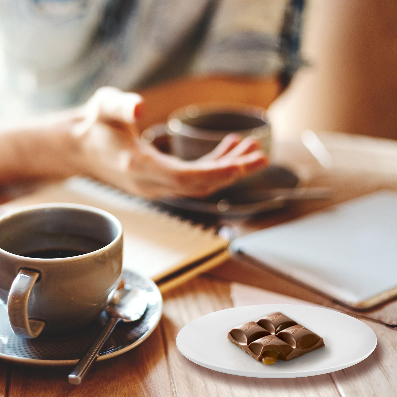 Cadbury Caramilk chocolate pieces served on a white plate beside a cup of coffee